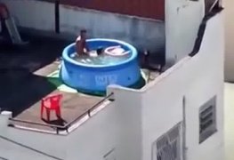 Filmando a trepada na piscina de plastico no terraço