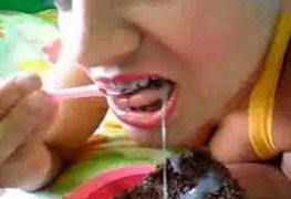 Novinha de aparelho comendo bolo com porra